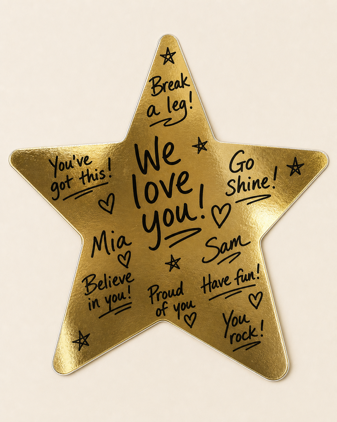 A shiny metallic gold star sticker with handwritten marker good-luck messages written across it.