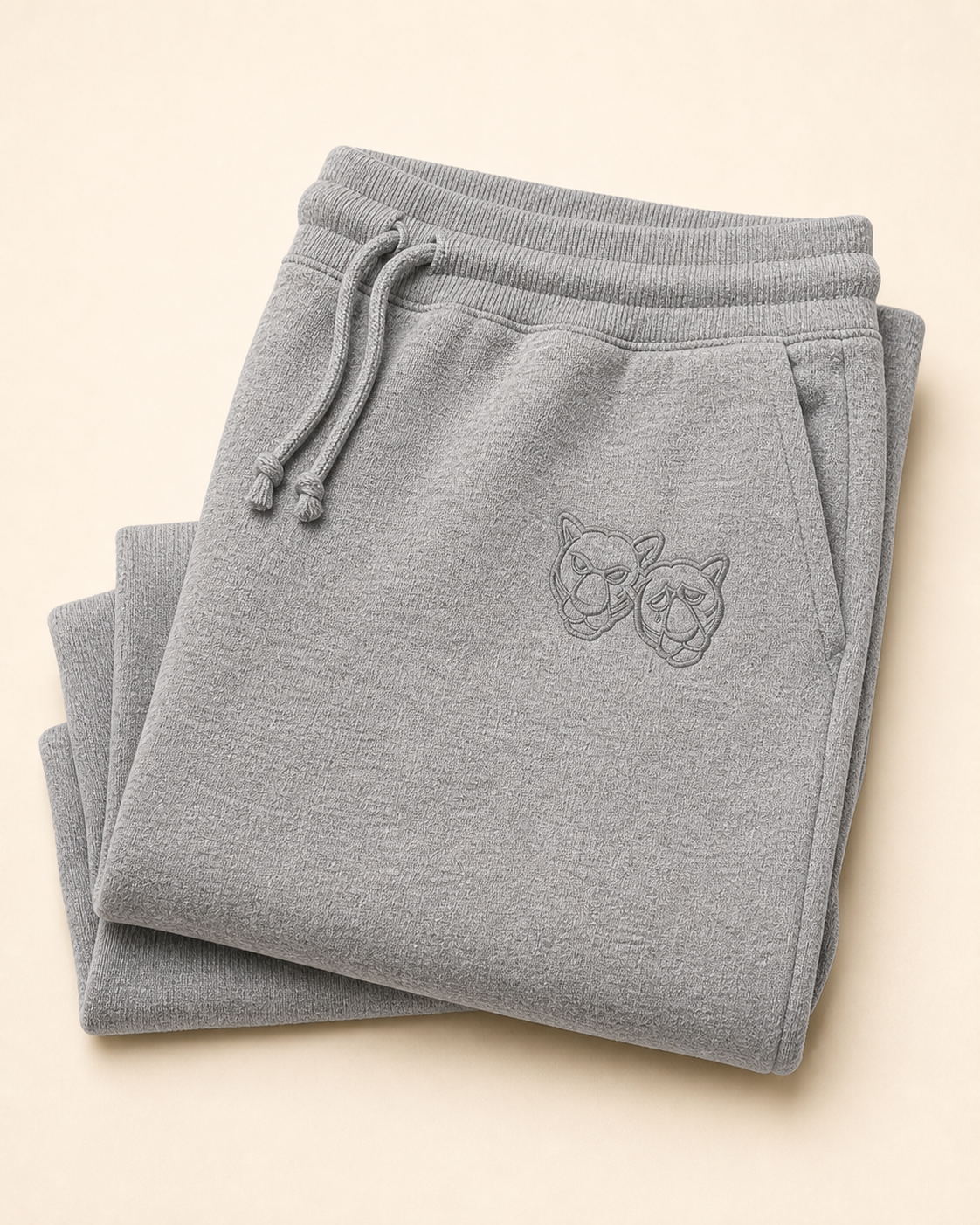 Folded heather-gray jogger sweatpants with a small tonal embroidered Panther crest on the hip.