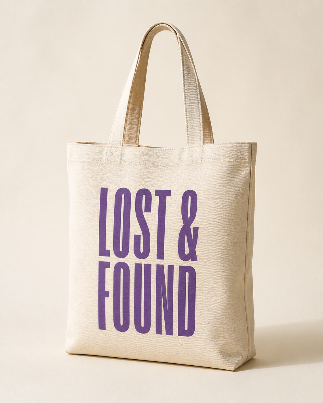 Natural canvas tote bag screen-printed with the Lost and Found wordmark.